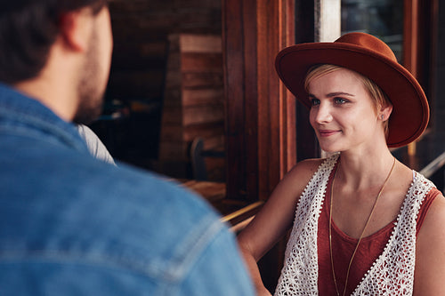Beautiful young woman sitting at a cafe with her friend