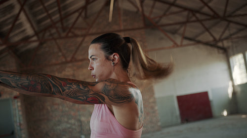 Muscular woman exercising with kettle bell in gym
