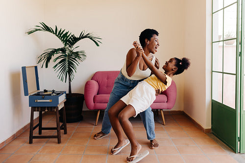 Girl dancing with her mom with music from a vinyl record player