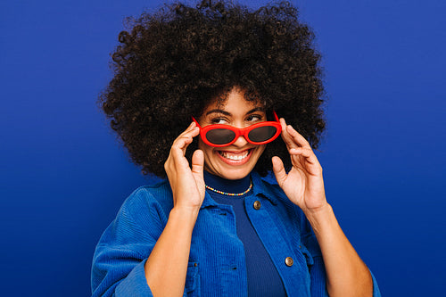 Fashionable young woman smiling while wearing trendy sunglasses