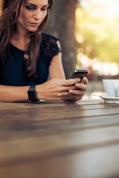 Woman texting with her mobile phone at cafe