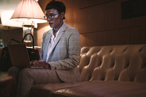 Businesswoman working on laptop at hotel lobby