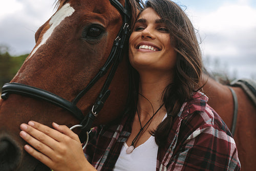 Happy woman hugging her horse