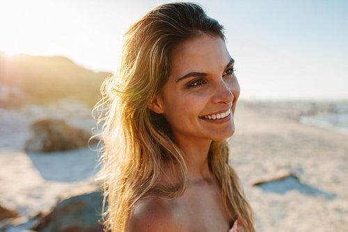 Happy woman on the beach looking away