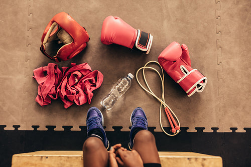 Top view of a kid sitting with boxing accessories
