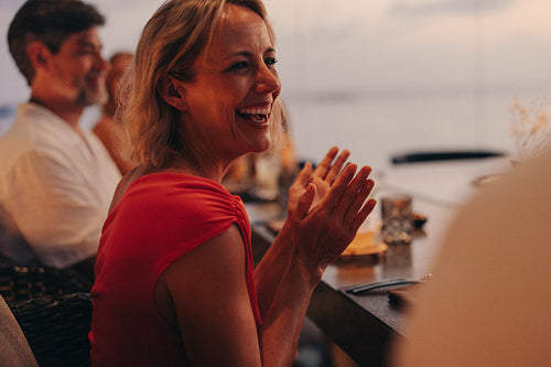Woman enjoying a cheerful meal at a restaurant with friends