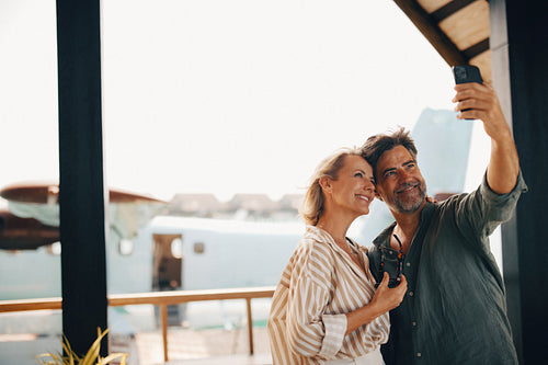 Couple taking a selfie at luxury travel destination with seaplane