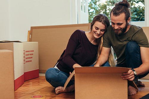 Happy couple looking at their articles packed in a box.