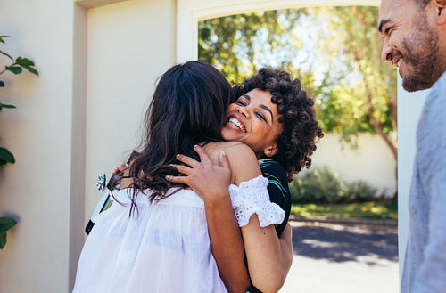 Couple welcoming friend for housewarming party