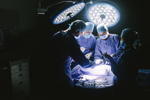 Surgeons performing surgical procedure in operating theatre