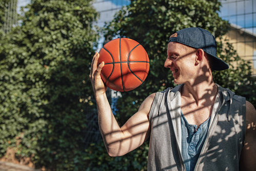 Young man looking at basketball in hand