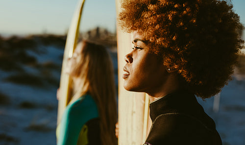 Surfers on the beach at sunset