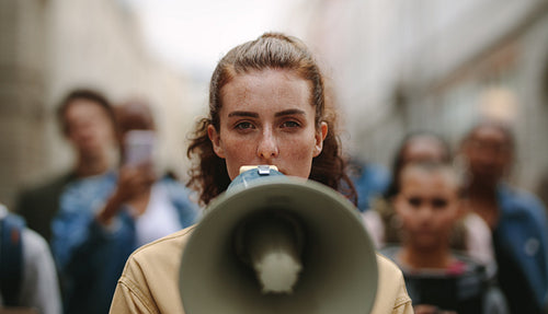 Female activist protesting with megaphone during a strike