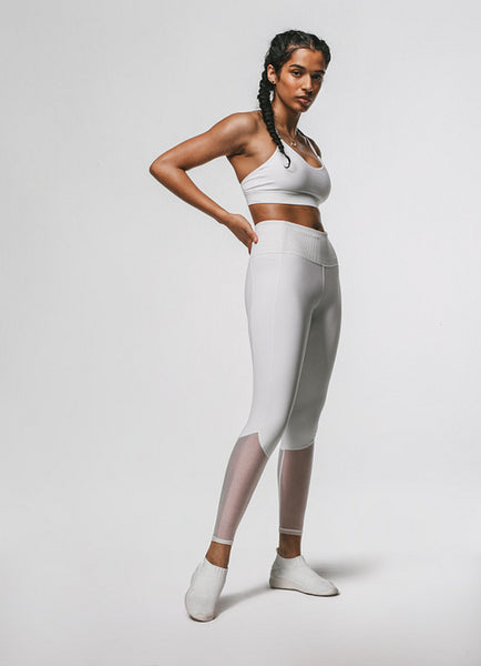 Portrait of fit woman standing against white background