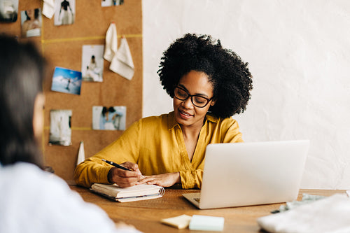 Successful female entrepreneur consulting with a fashion design client in her office