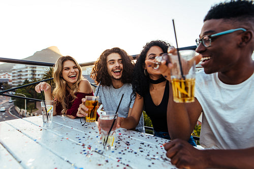 Friends enjoying rooftop party with drinks