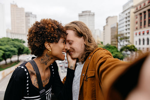 Romantic embrace for a selfie on the city streets by a loving pair