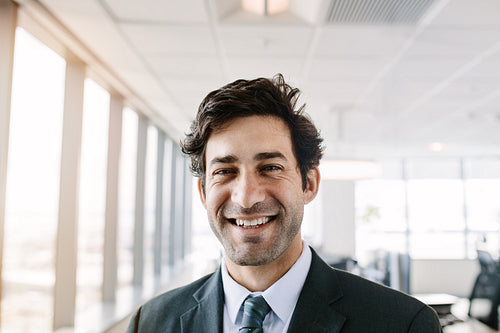 Successful young businessman standing in office