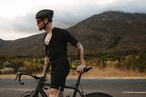 Determined male cyclist with bicycle