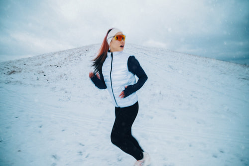 Winter running carries a woman across snowy ground during outdoor training