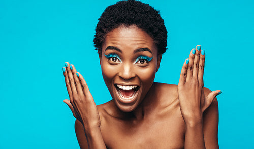 Excited female model showing her vivid makeup