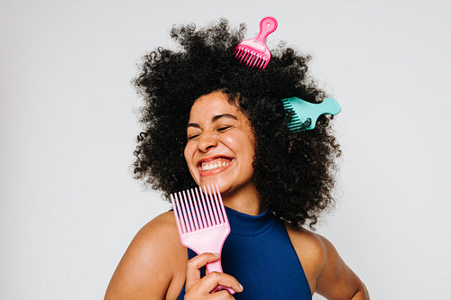 Beautiful woman with Afro hair having fun with fork combs