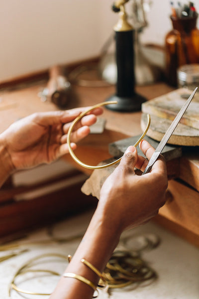 Artist hands making and examining jewelry