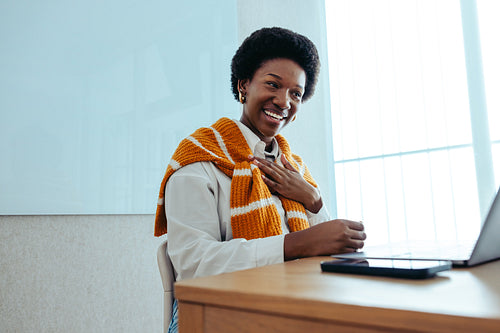 Professional woman blushing in appreciation during a virtual office meeting on her laptop