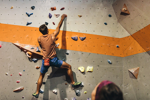 Man climbing indoor boulder wall