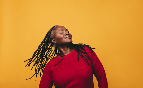 Beautiful black woman whipping her dreadlocks in a studio