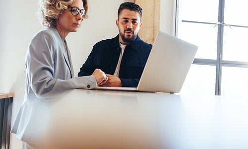 Business colleagues looking at a slideshow presentation on a laptop