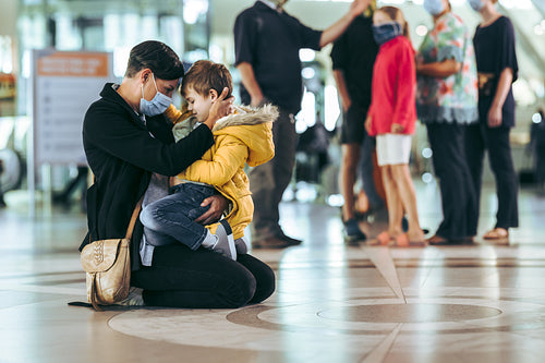 Woman with her son at airport during pandemic