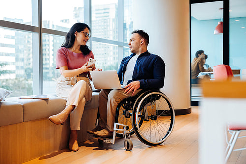 Professional friends discuss ideas in modern coworking space