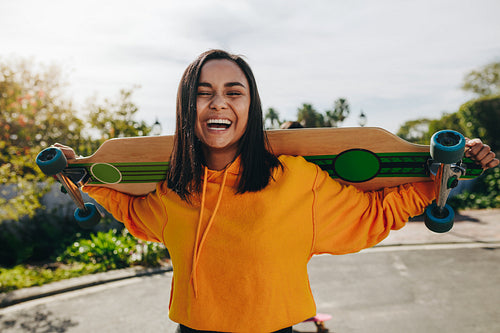 Girl standing in street with a longboard