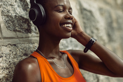 Runner enjoying listening music while having break