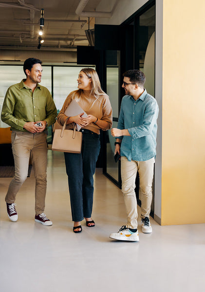 Young professionals walking through a modern office talking and smiling