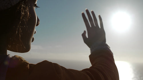Woman looks like touching the sun