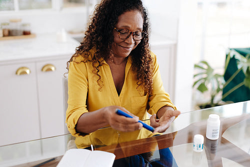 Woman with diabetes giving herself insulin therapy using an insulin pen needle