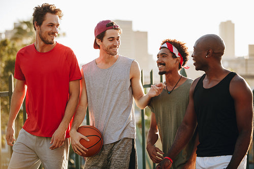 Basketball guys walking on pavement with the ball