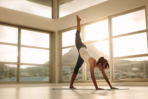 Fitness woman in Adho Mukha Svanasana pose at gym