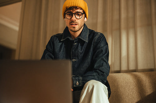 Business man works at a laptop in a creative office portrait