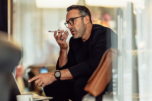 Businessman sitting in hotel waiting area making call
