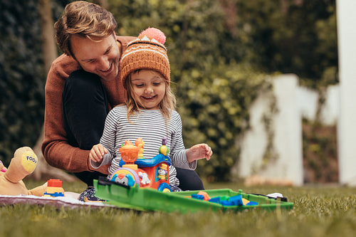 Father and daughter playing with toys in park