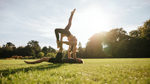 Strong young couple doing acroyoga workout