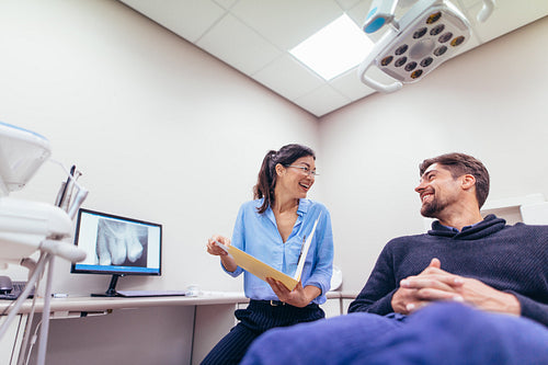 Smiling dentist and patient at dental clinic
