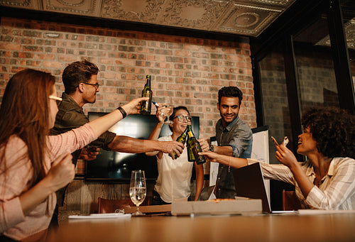 Multi-ethnic business people celebrating a success with beers