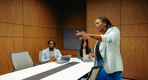 African female professional leading a boardroom presentation