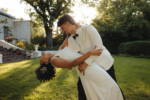 Newlyweds sharing a romantic dance in an outdoor garden setting