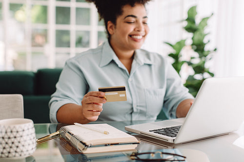 Woman doing online shopping using credit card and laptop