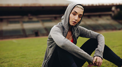 Fitness woman sitting in a stadium after workout